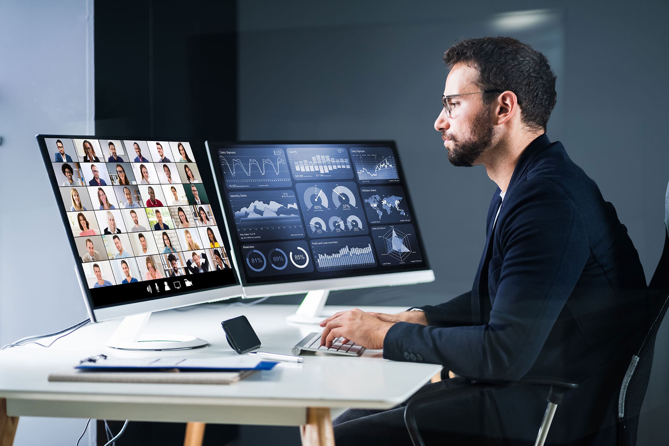 Man working on two desktop screens