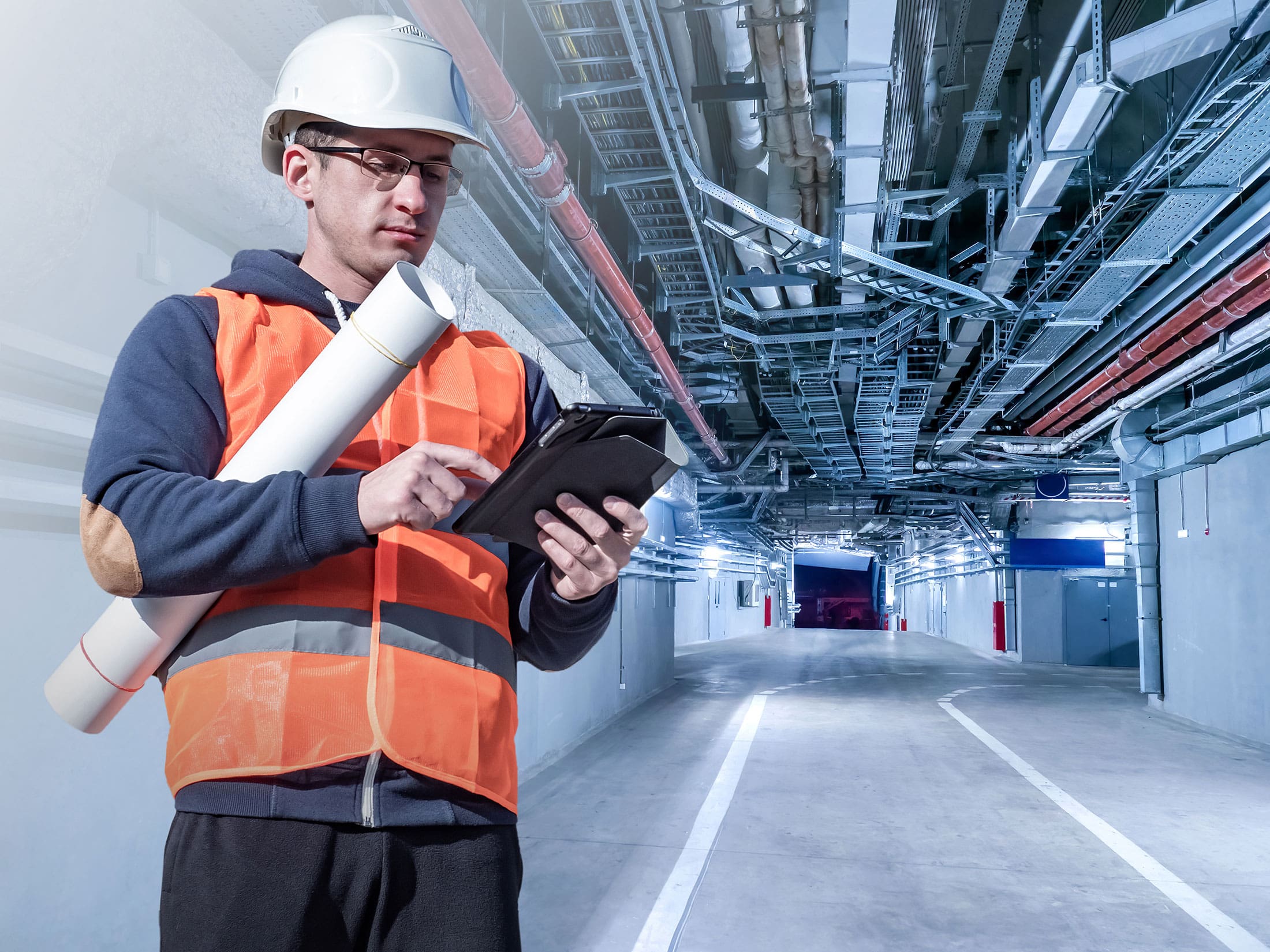 an onsite picture of a SITA employee carrying a white tube under his arm and checking plans on his tablet phone