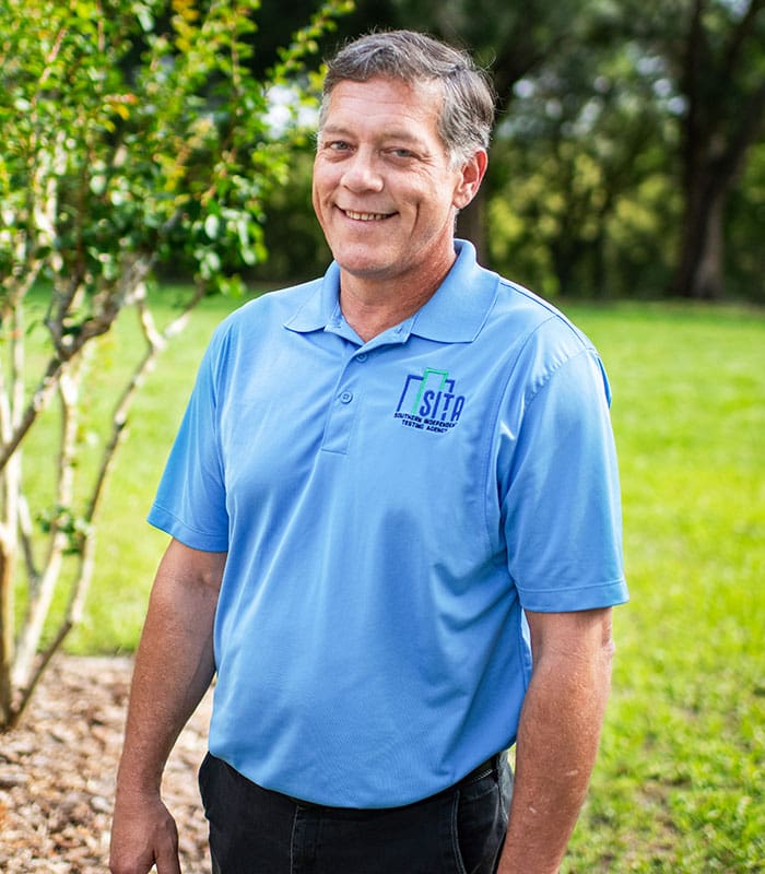 a picture of Nathaniel J. Crimm, the Project Coordinator of SITA, smiling and posing outside on a sunny day