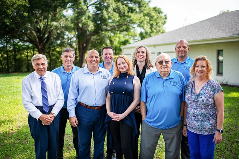 a picture of the SITA management team, all 9 of them standing with smiles, wearing the colour blue of the company