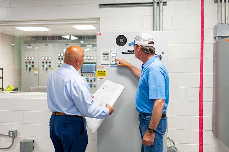 Two men that work at SITA are working on proper installations of huilding HVAC Commissioning