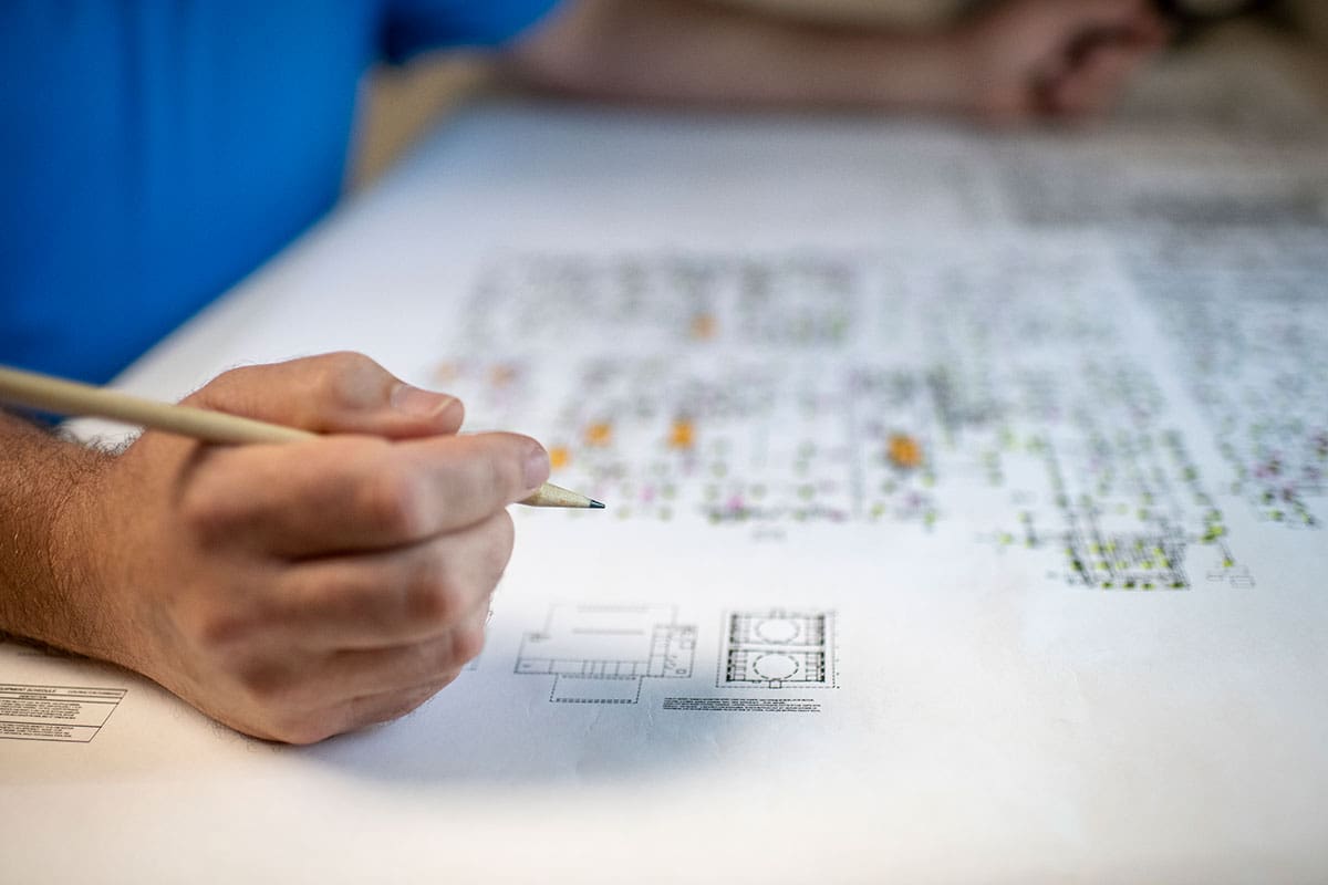 A man drawing out floor plans and residential blower door testing systems