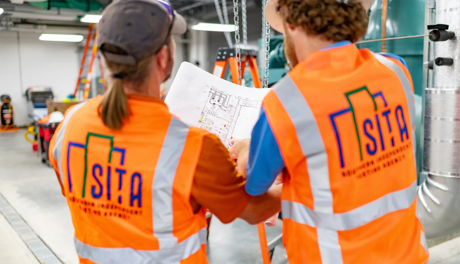 Blog-Cover-Images2200-x-1265-px-28 SITA-TAB technicians reviewing HVAC blueprints on-site, ensuring precise implementation of testing, adjusting, and balancing procedures for system efficiency.