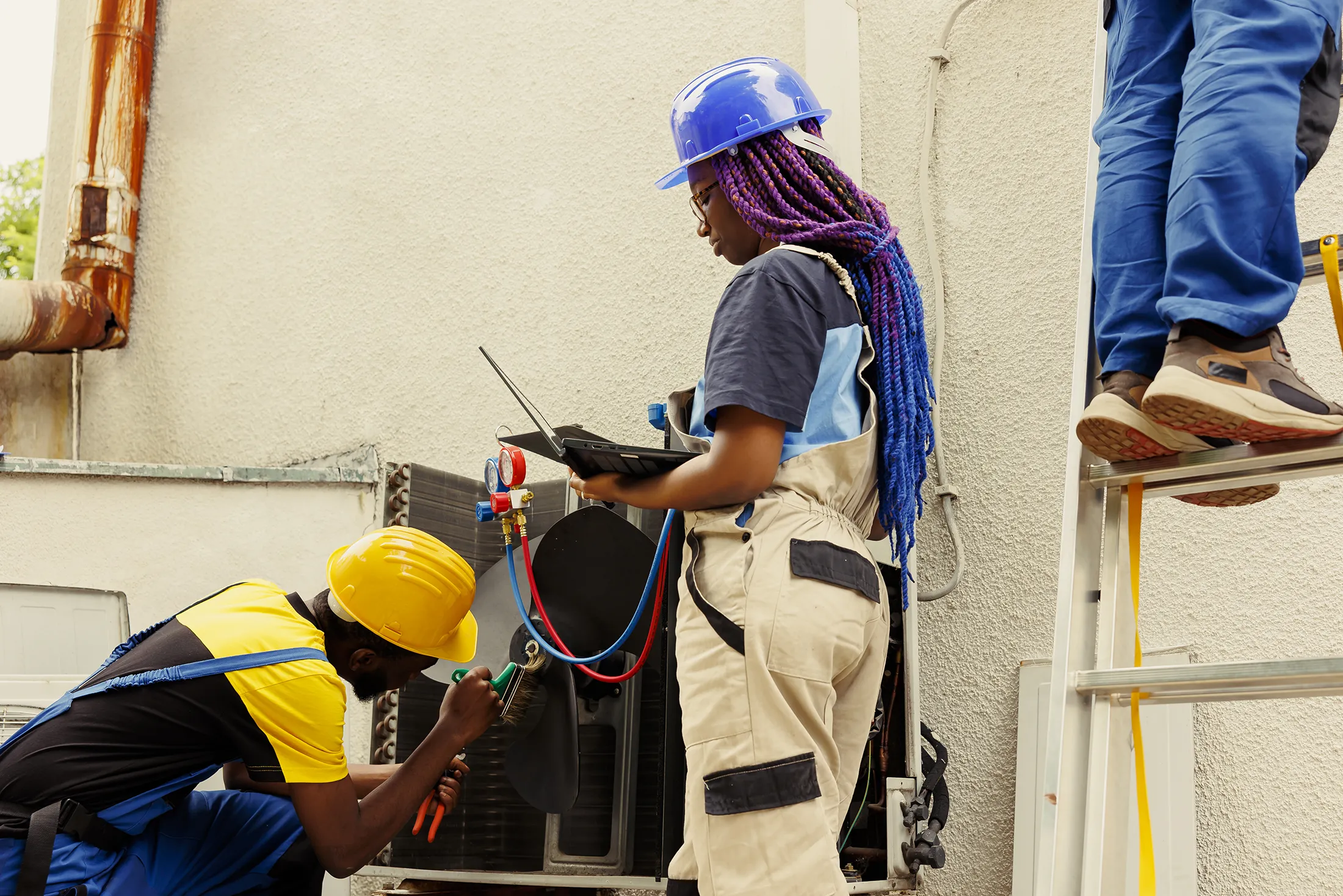 engineer-reconditioning-condenser-2025-02-19-22-46-19-utc HVAC technicians servicing outdoor AC unit with tablet diagnostics.